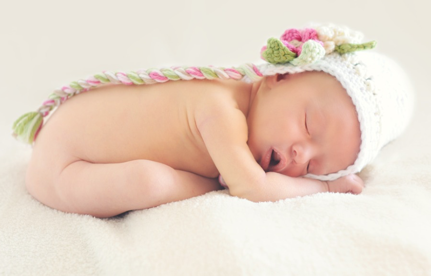 Naked newborn in knitted hat